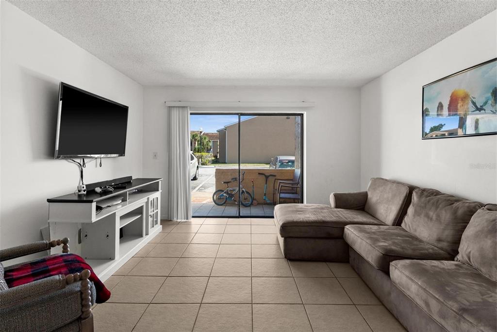 5201 Vineland Road, Unit 112 Orlando, FL 32811 - Photo 4 of 25 a living room with furniture and a flat screen tv