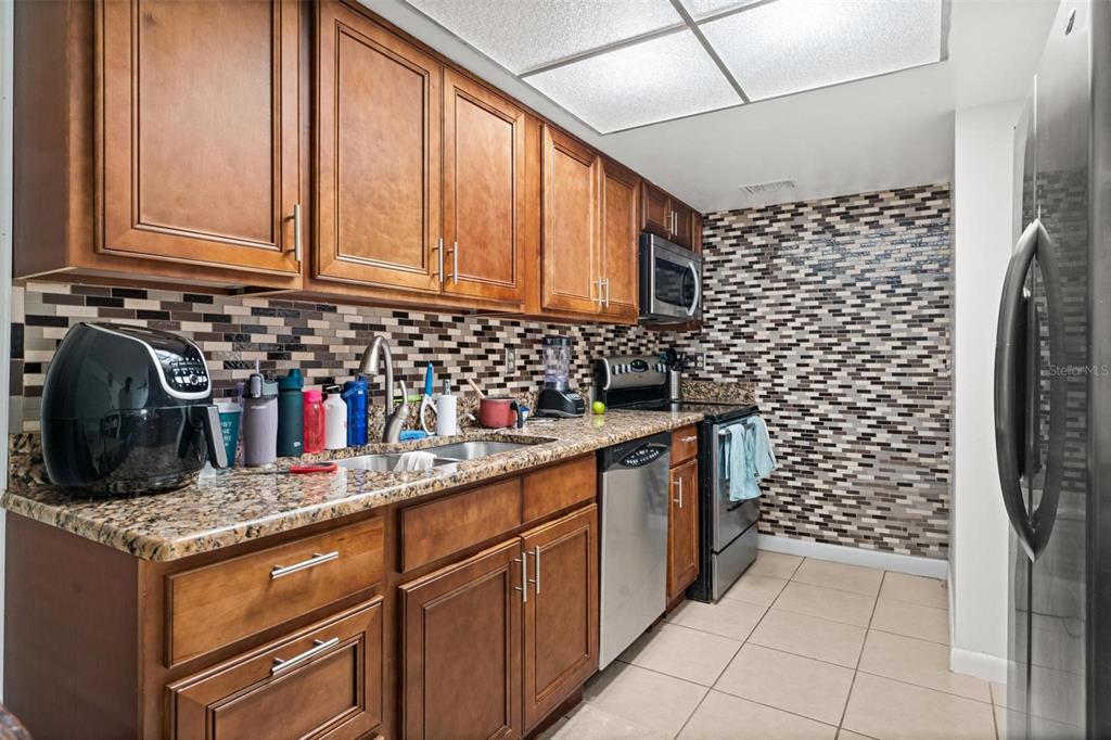 5201 Vineland Road, Unit 112 Orlando, FL 32811 - Photo 5 of 25 a kitchen with refrigerator and cabinets
