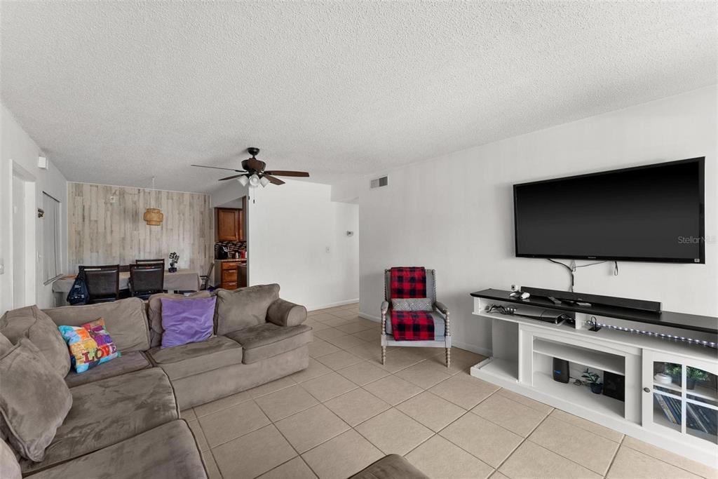 5201 Vineland Road, Unit 112 Orlando, FL 32811 - Photo 7 of 25 a living room with furniture and a flat screen tv
