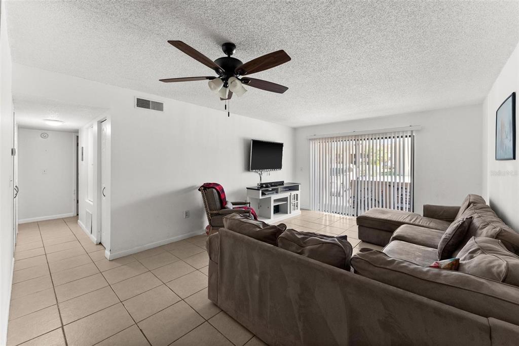 5201 Vineland Road, Unit 112 Orlando, FL 32811 - Photo 9 of 25 a living room with furniture and a flat screen tv