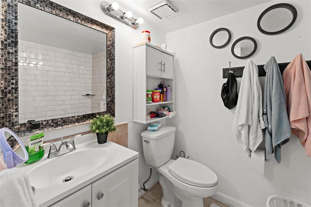 5201 Vineland Road, Unit 112 Orlando, FL 32811 - Photo 10 of 25 a bathroom with a toilet a sink and a mirror