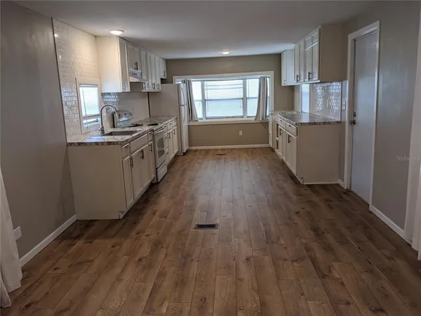 a kitchen with stainless steel appliances a refrigerator and a stove top oven