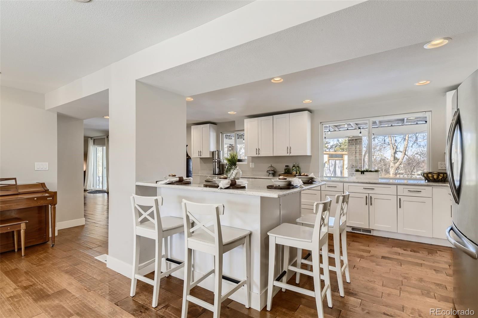 4165 East Peakview Circle Centennial, CO 80121 - Photo 9 of 27 a kitchen with a dining table chairs cabinets and stainless steel appliances