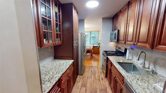 a kitchen with granite countertop a sink a stove and cabinets
