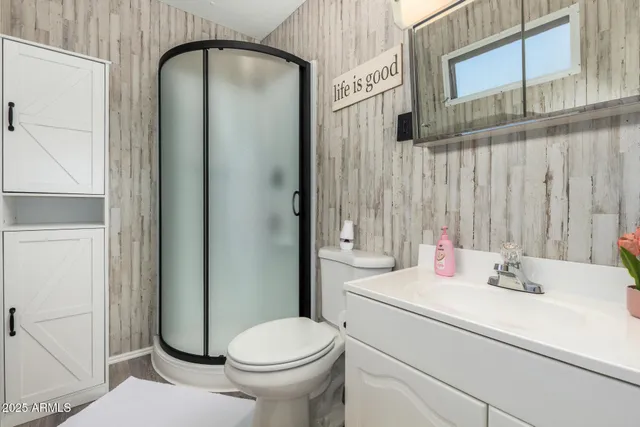 a bathroom with a sink a toilet and shower