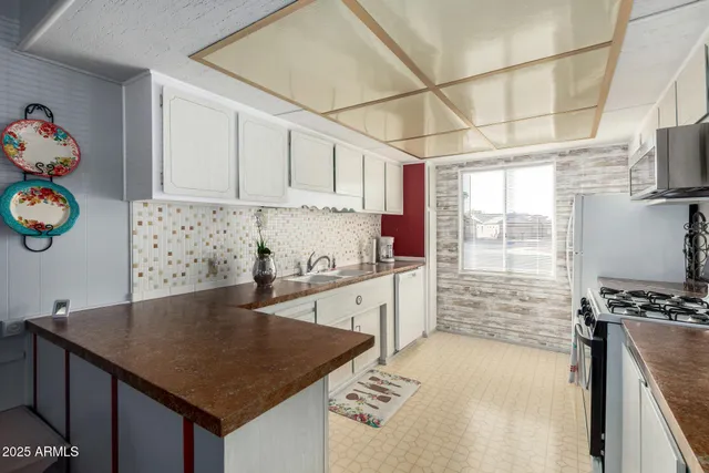 a kitchen with granite countertop a sink a stove and cabinets