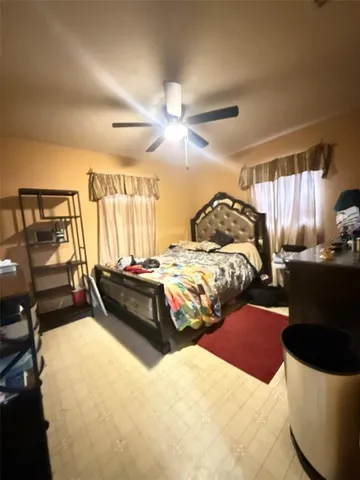 a bedroom with a bed a couch and a chandelier