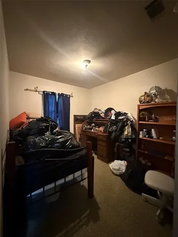 a spacious bedroom with a bed and a chandelier