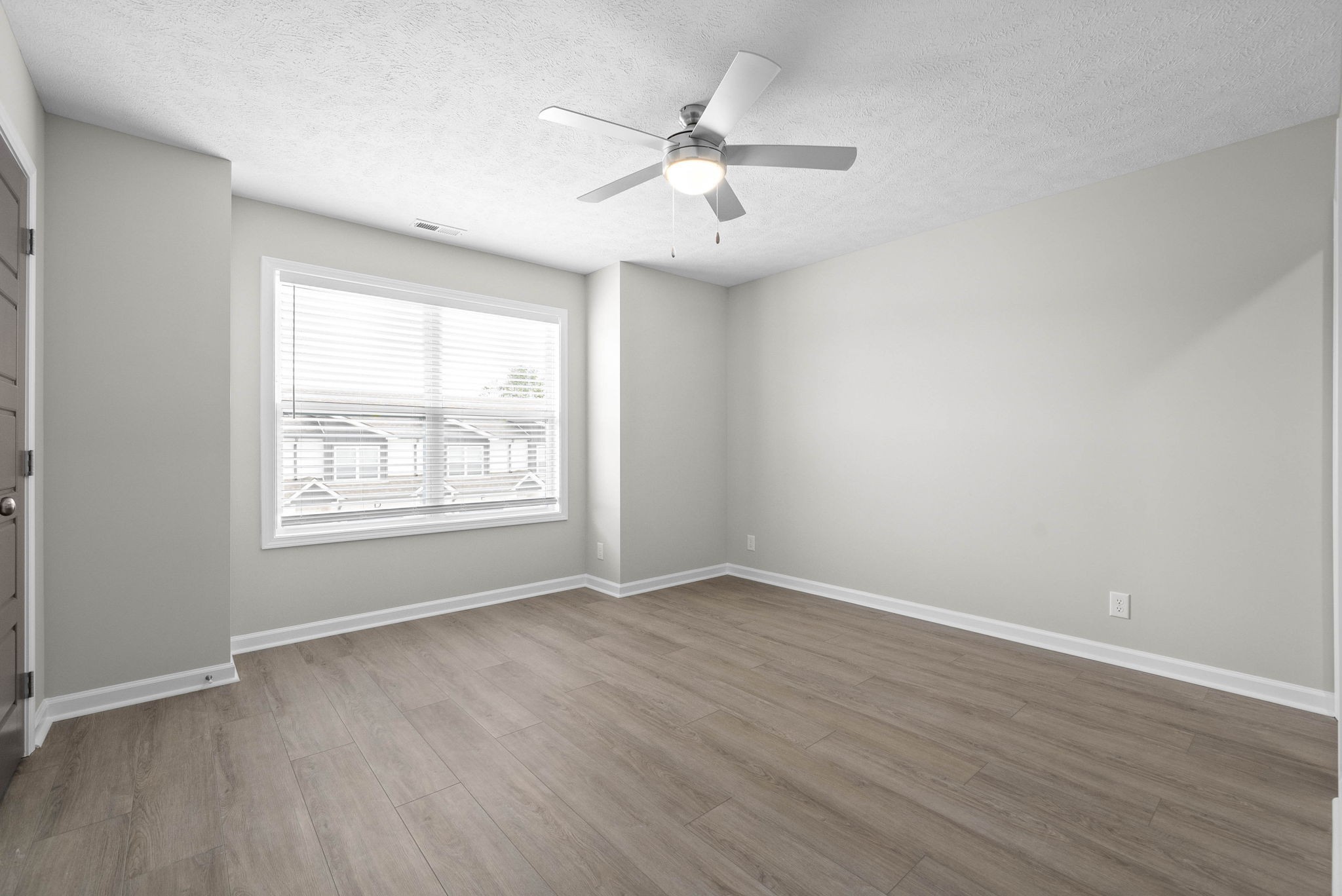 317 Longshadow Trail, Unit F Clarksville, TN 37043 - Photo 15 of 30 an empty room with wooden floor chandelier fan and windows
