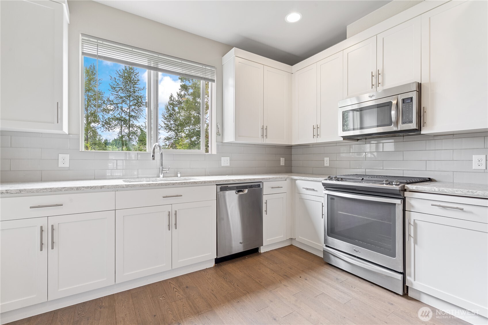 4239 Northeast 3rd Lane Renton, WA 98059 - Photo 12 of 28 a kitchen with granite countertop white cabinets stainless steel appliances and window