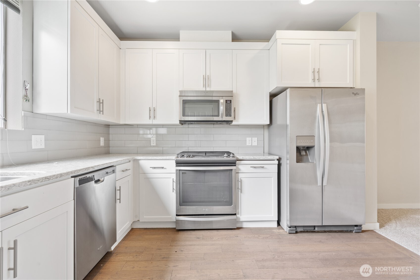4239 Northeast 3rd Lane Renton, WA 98059 - Photo 13 of 28 a kitchen with stainless steel appliances granite countertop a refrigerator stove and white cabinets