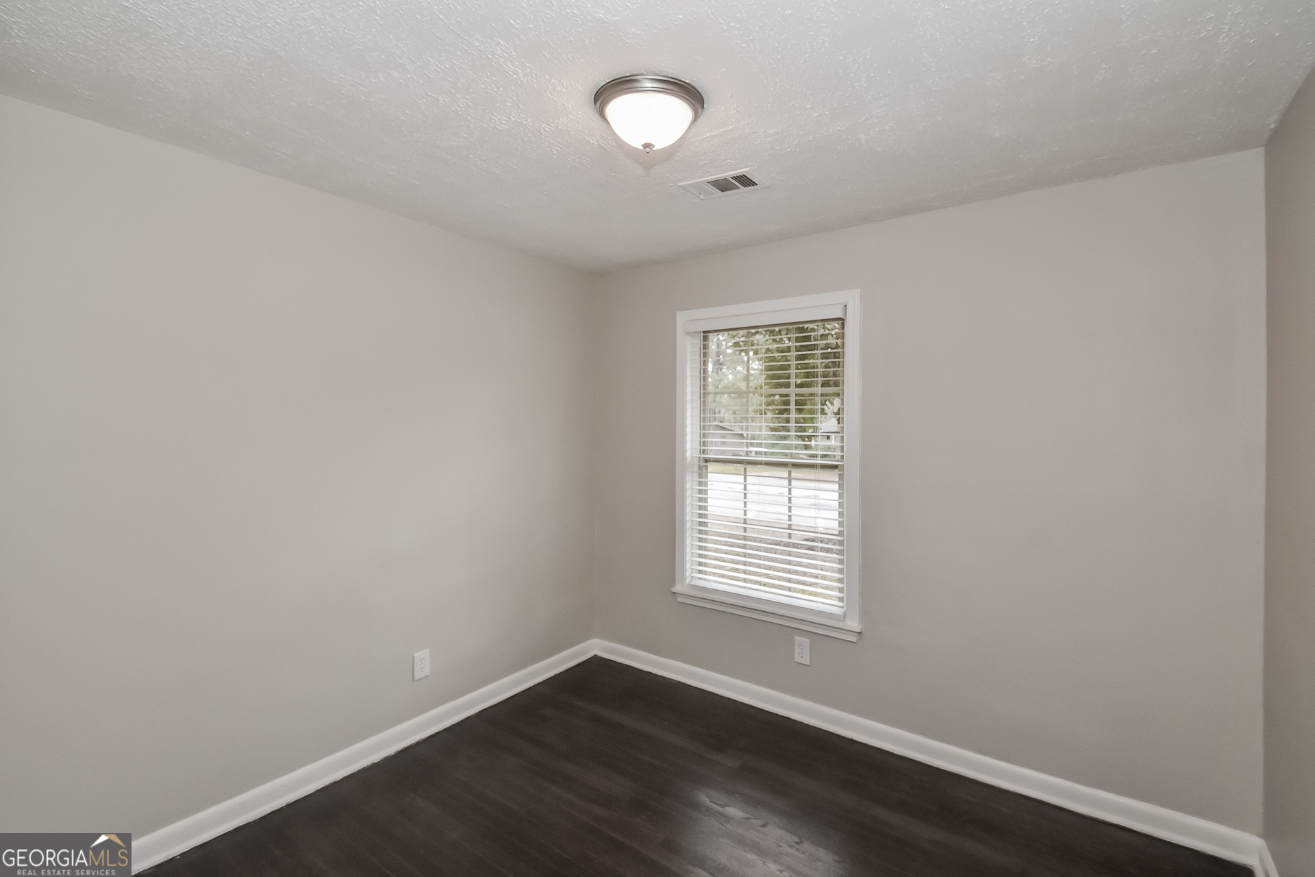 3803 Bakers Ferry Road Southwest Atlanta, GA 30331 - Photo 11 of 16 an empty room with wooden floor and windows