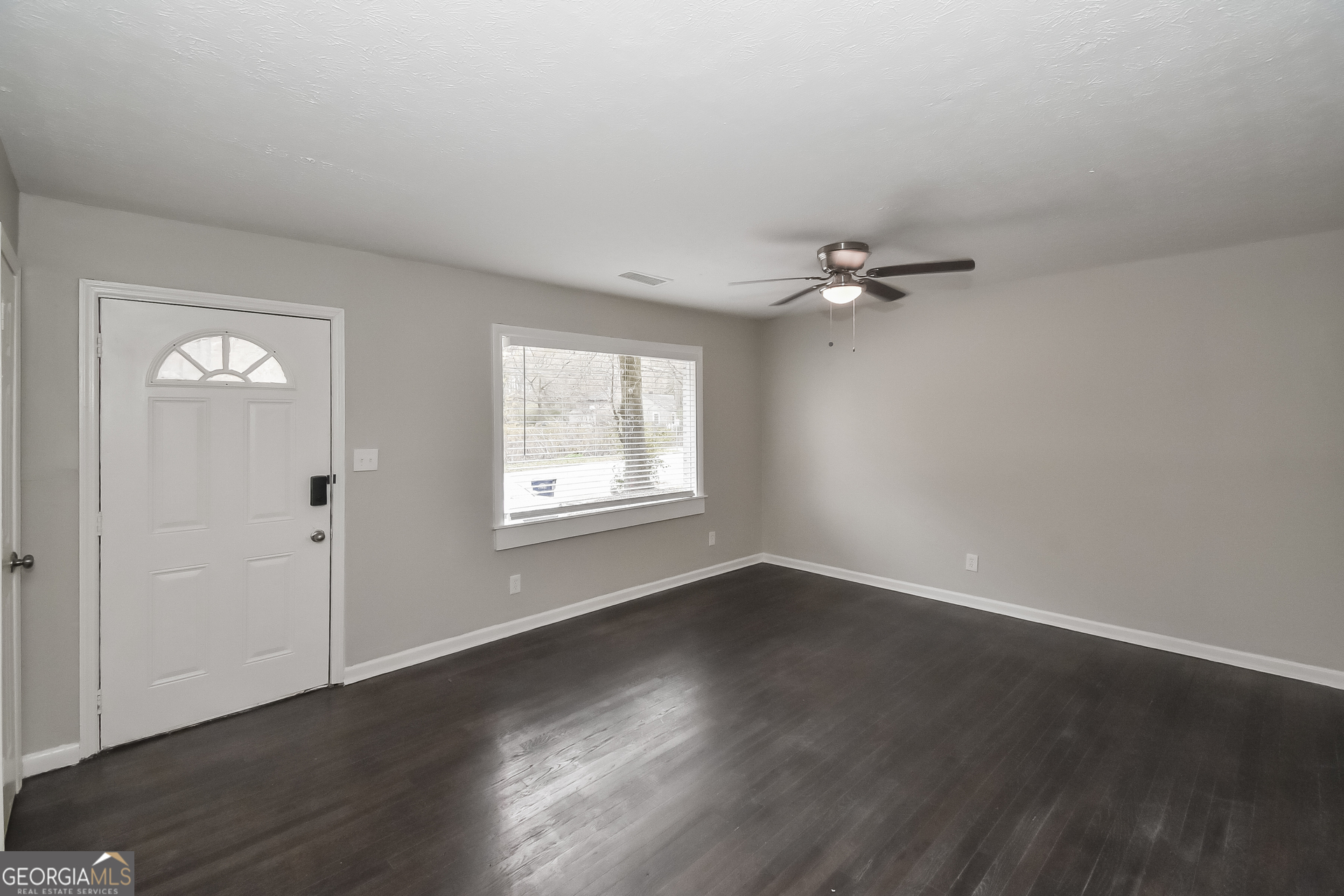 3803 Bakers Ferry Road Southwest Atlanta, GA 30331 - Photo 4 of 16 a view of an empty room with a window and wooden floor