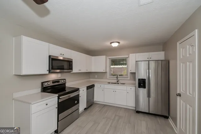 a kitchen with a sink a stove a microwave and refrigerator