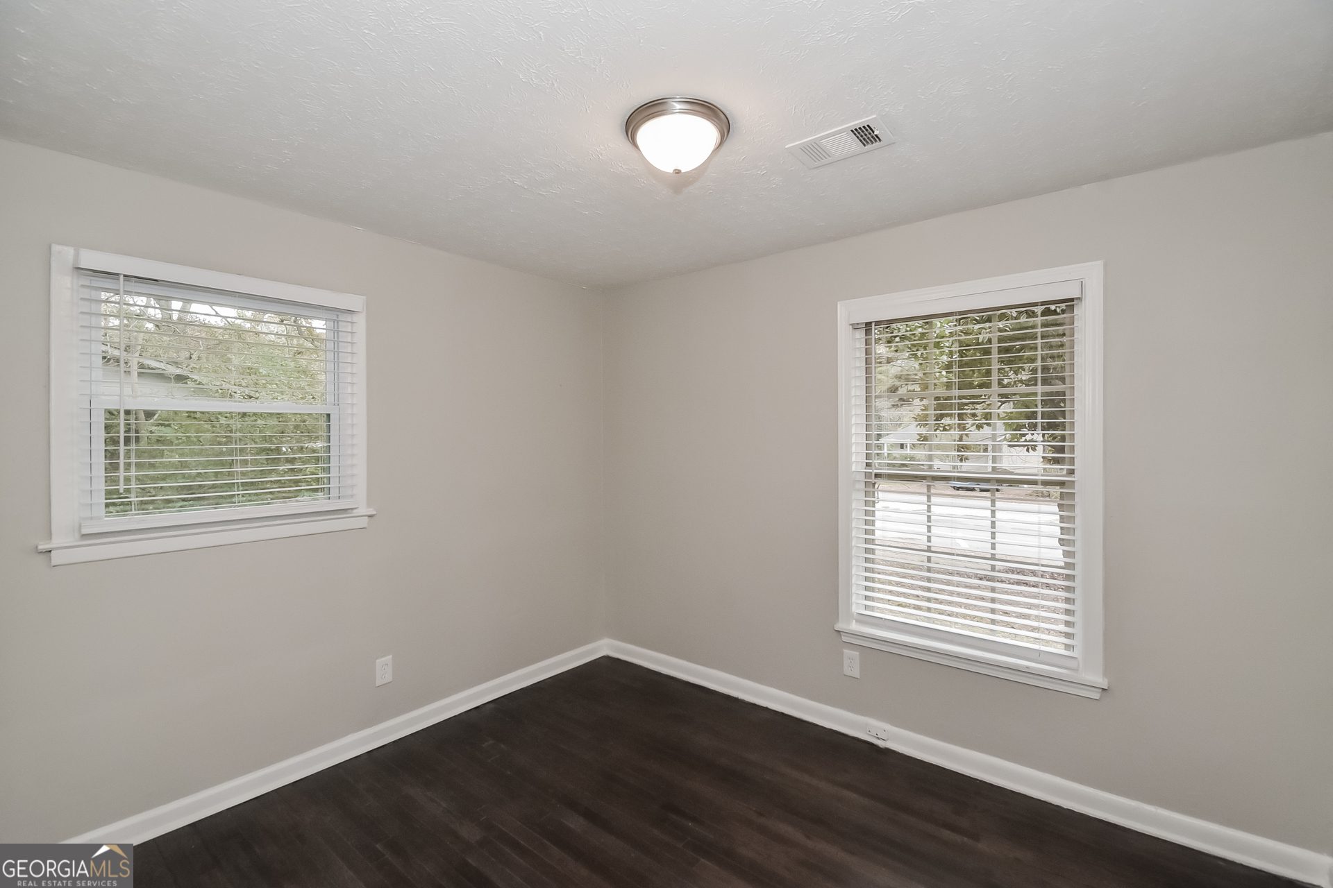 3803 Bakers Ferry Road Southwest Atlanta, GA 30331 - Photo 10 of 16 a view of an empty room with wooden floor and a window