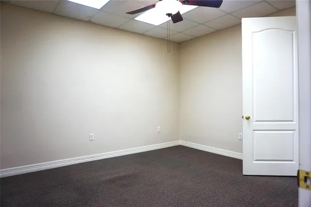 an empty room with a ceiling fan and a window