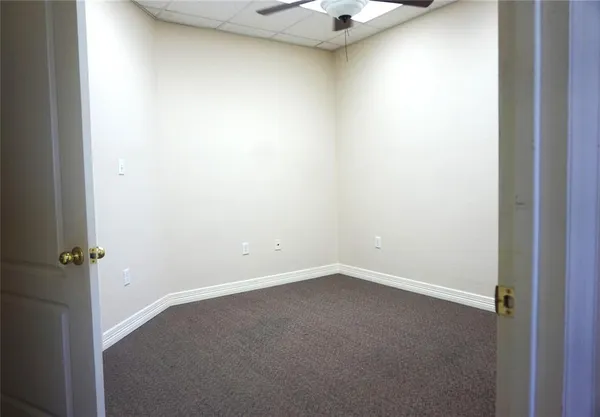 an empty room with a ceiling fan and a window