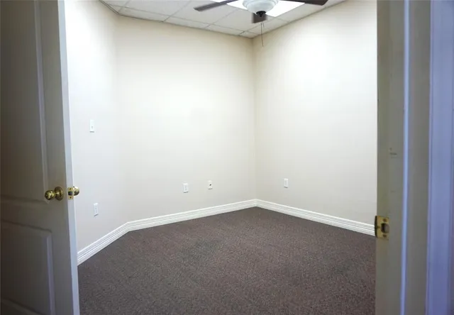 an empty room with a ceiling fan and a window