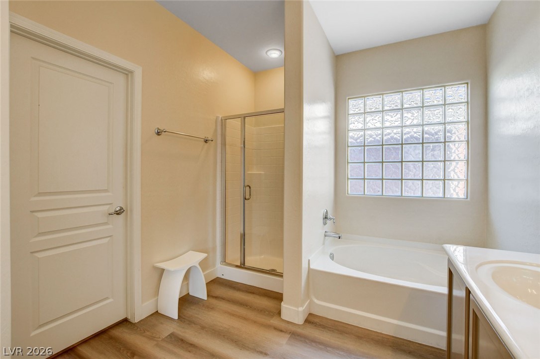 2649 Rue Marquette Avenue Henderson, NV 89044 - Photo 46 of 55 This primary bathroom features a glass-enclosed shower, a deep soaking tub, and a window for natural light.