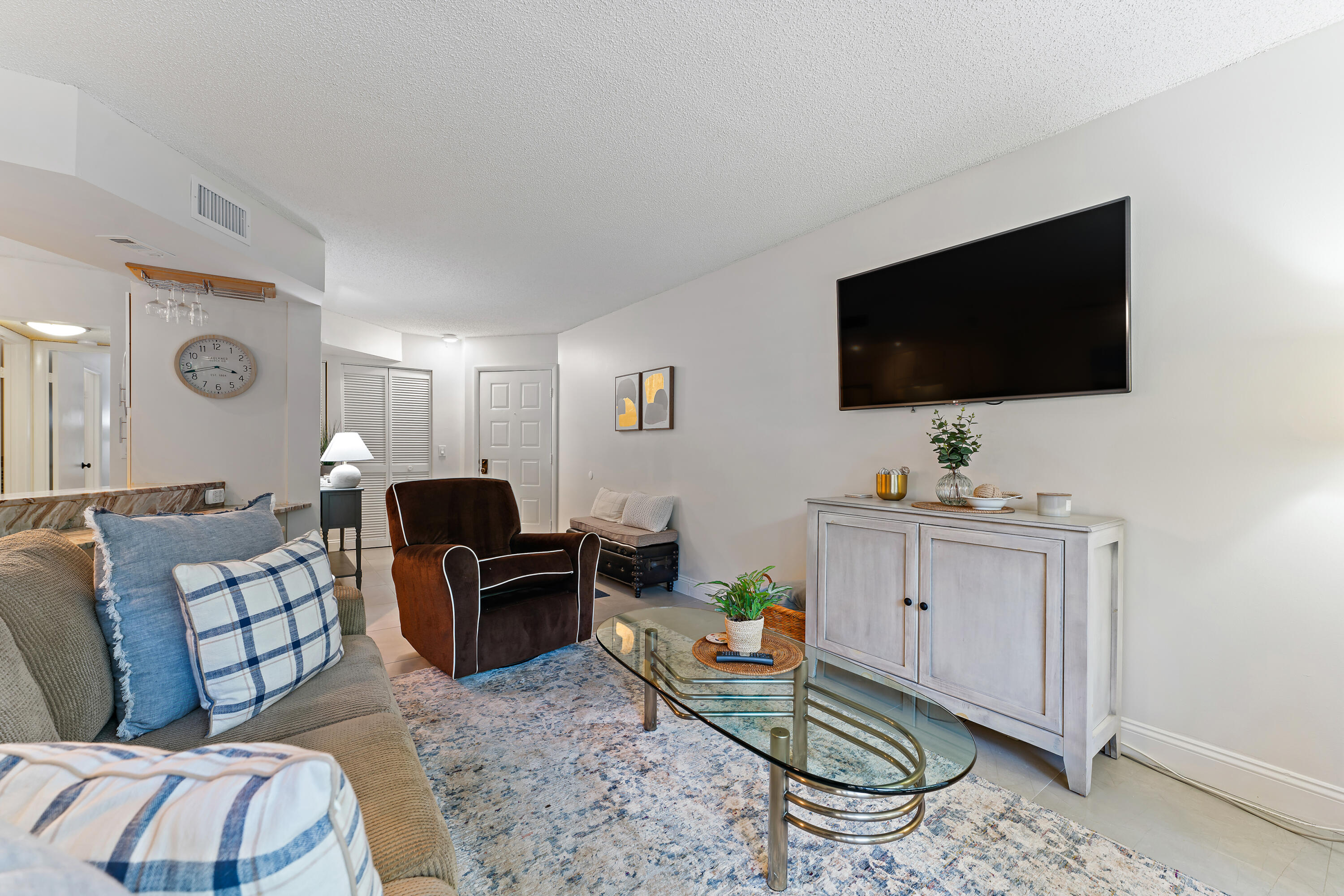 1605 Highway 1, Unit E104 Jupiter, FL 33477 - Photo 11 of 34 a living room with furniture a flat screen tv and kitchen view