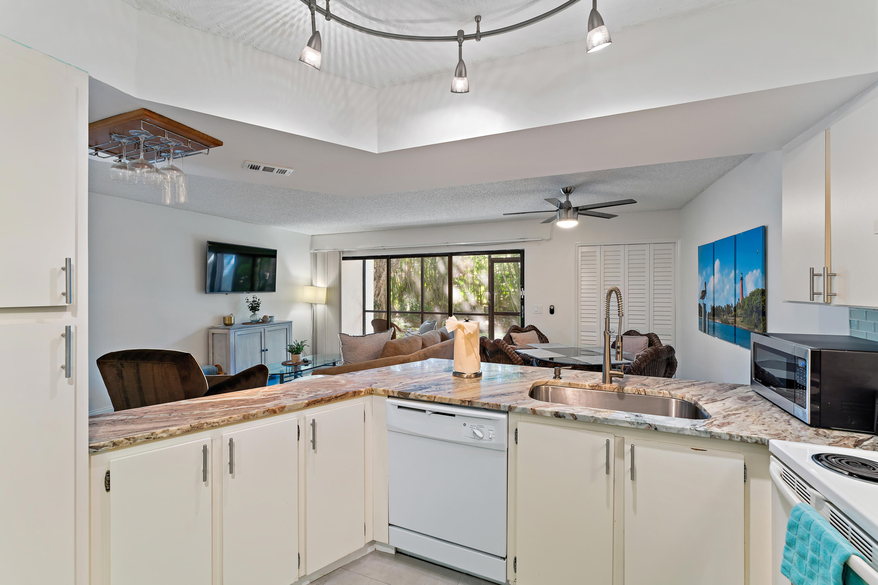 1605 Highway 1, Unit E104 Jupiter, FL 33477 - Photo 20 of 34 a kitchen with counter top space a sink and appliances