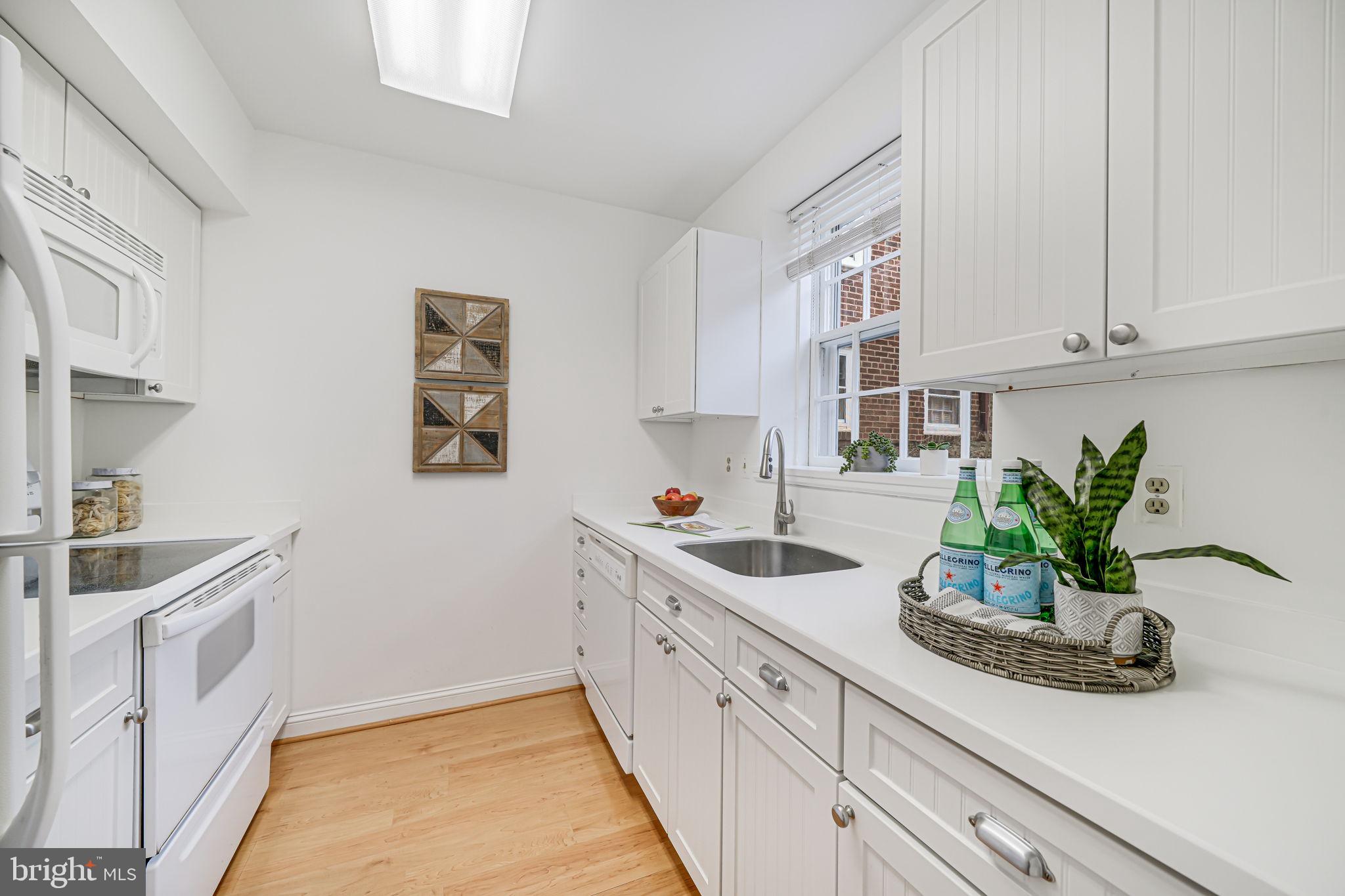 3701 39th Street Northwest, Unit A181 Washington, DC 20016 - Photo 10 of 68 a kitchen with stainless steel appliances white cabinets and a potted plant