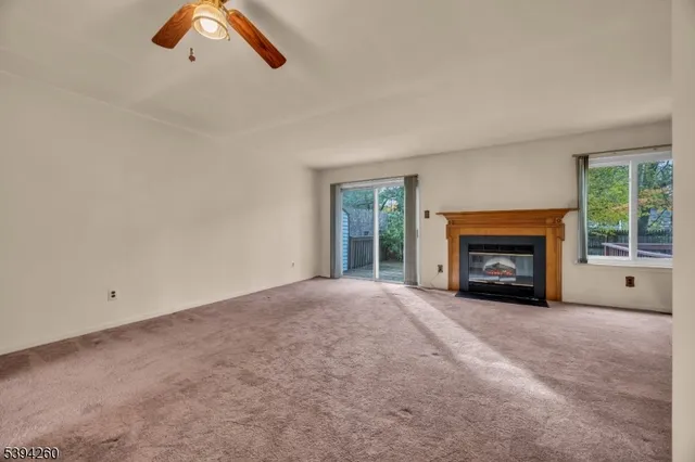 an empty room with windows and fireplace