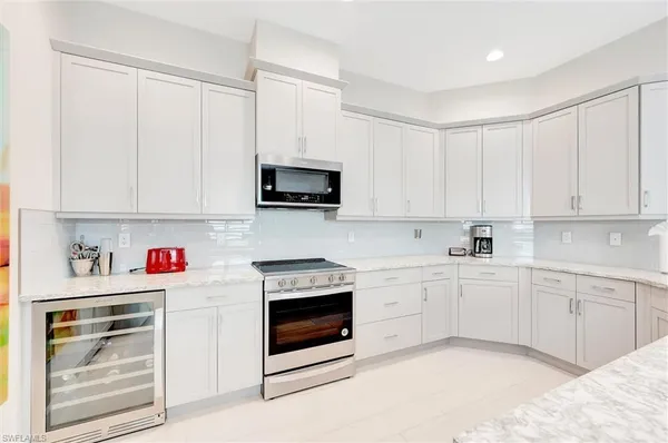 a kitchen with white cabinets and white appliances