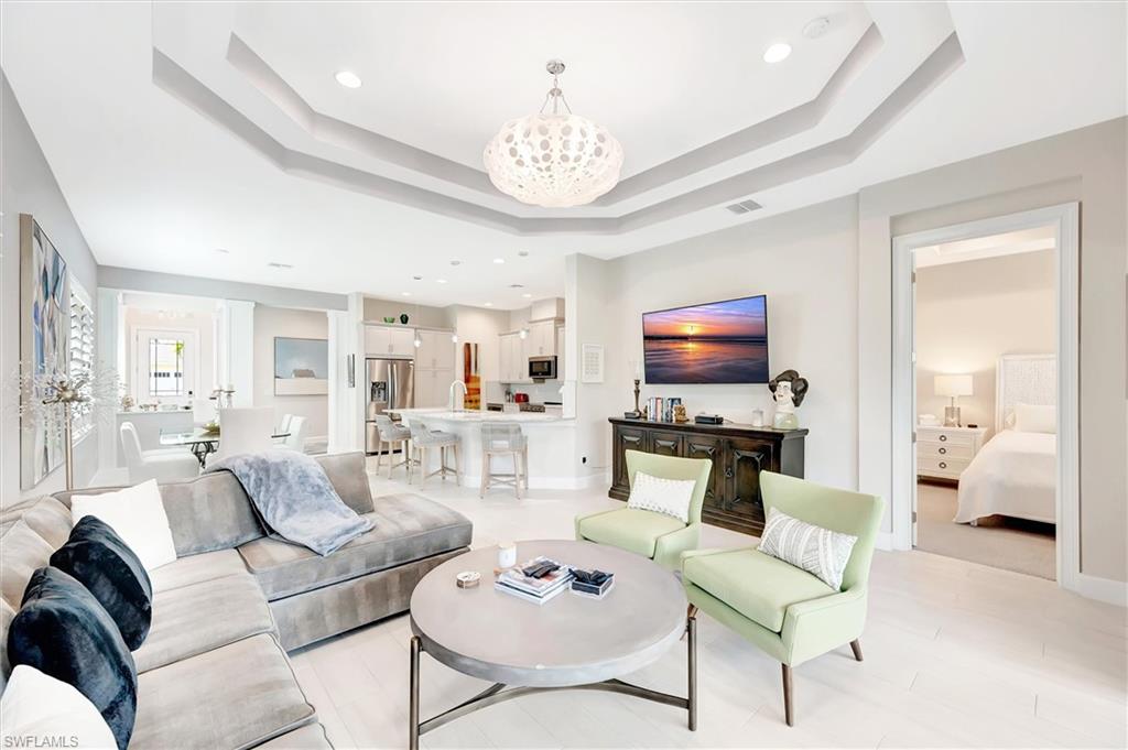 5743 Highbourne Drive Naples, FL 34113 - Photo 22 of 27 a living room with furniture a rug and a chandelier