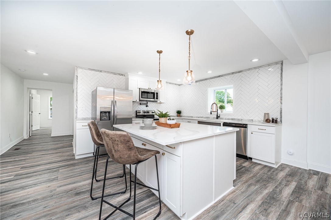 217 Henry Clay Road Ashland, VA 23005 - Photo 16 of 38 a kitchen with kitchen island a stove a table and chairs in it