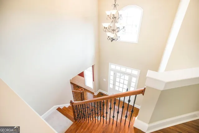 a view of staircase with railing and white walls