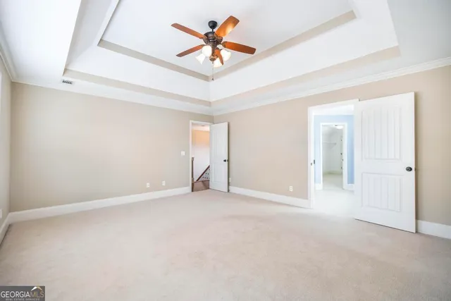 an empty room with closet and a ceiling fan