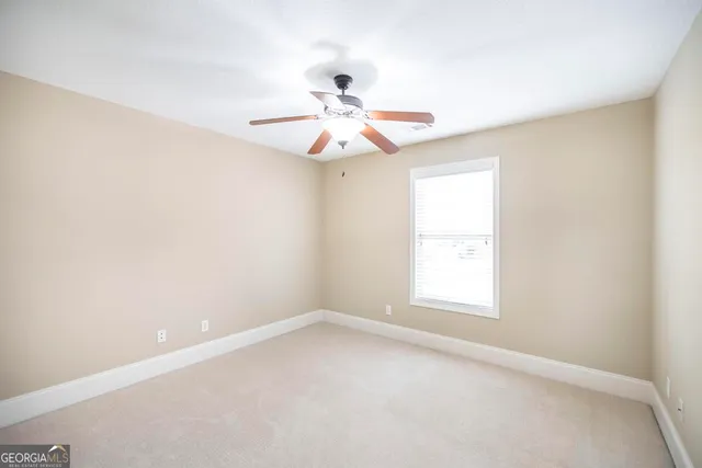an empty room with a window and a fan