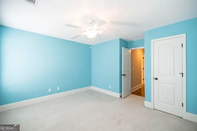 an empty room with closet and a chandelier fan