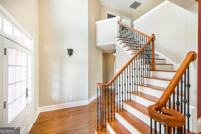 a view of staircase with lots of frames on wall and a window