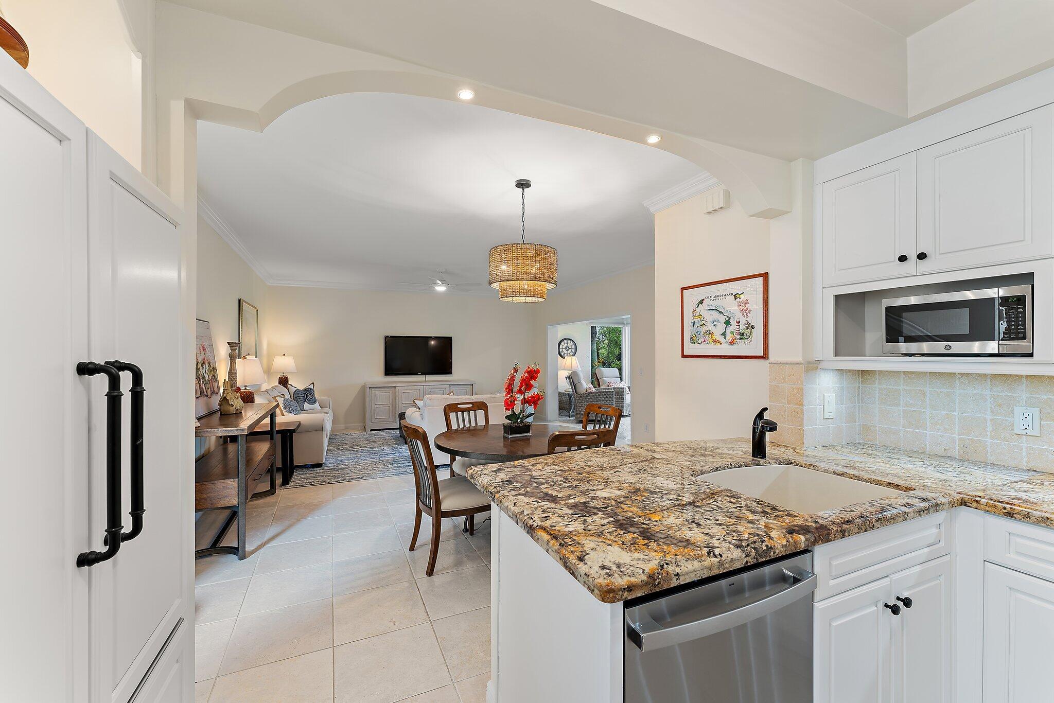 2905 Fairway Drive North Jupiter, FL 33477 - Photo 13 of 65 a kitchen island with granite countertop a table and chairs in it