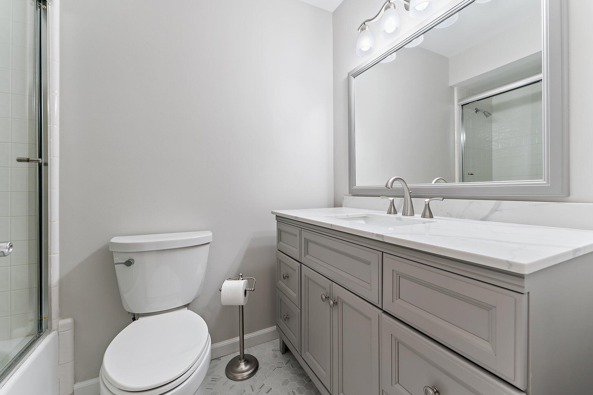 2905 Fairway Drive North Jupiter, FL 33477 - Photo 36 of 65 a bathroom with a toilet sink vanity and mirror