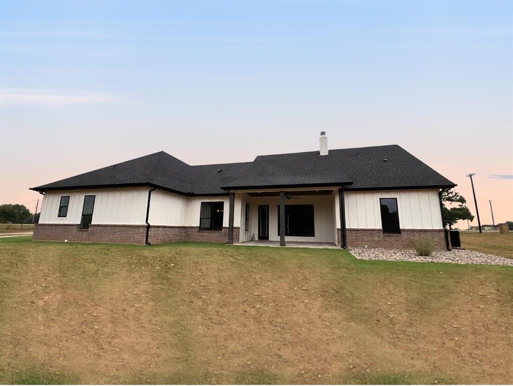 121 Cartwright Park Road Weatherford, TX 76087 - Photo 3 of 17 Modern farmhouse-style home featuring white vertical siding and a dark brick foundation