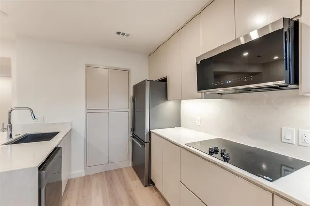 a kitchen with a refrigerator a sink and a microwave