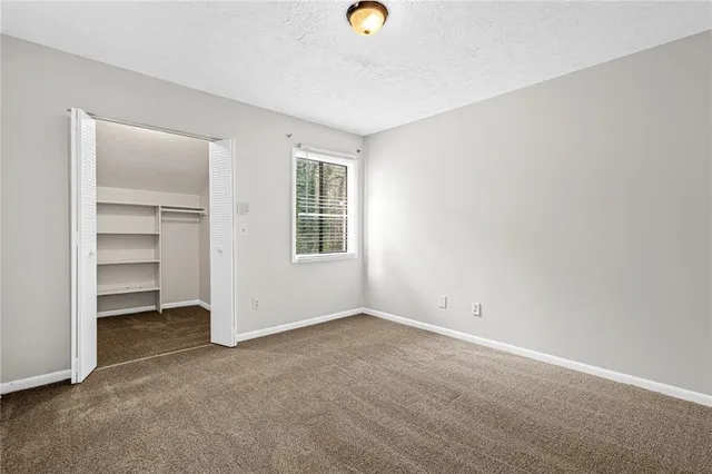 an empty room with closet and windows