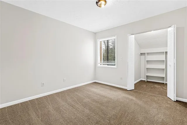 an empty room with a windows and closet