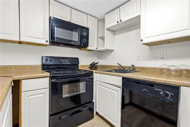 a kitchen with stainless steel appliances granite countertop a sink a stove a microwave oven and cabinets