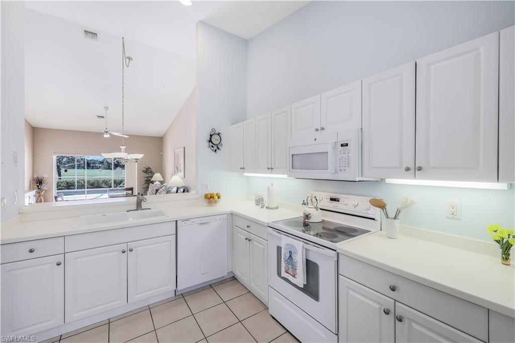 6667 Castlelawn Place, Unit 19 Naples, FL 34113 - Photo 11 of 31 a kitchen with cabinets appliances a sink and a counter top