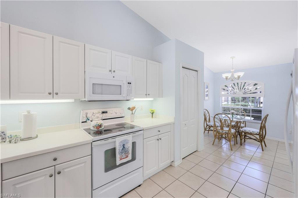 6667 Castlelawn Place, Unit 19 Naples, FL 34113 - Photo 12 of 31 a kitchen with cabinets and chairs