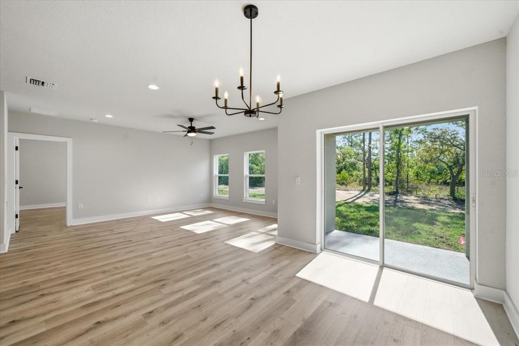 15212 Hawley Road Weeki Wachee, FL 34614 - Photo 12 of 25 a view of empty room with wooden floor and fan