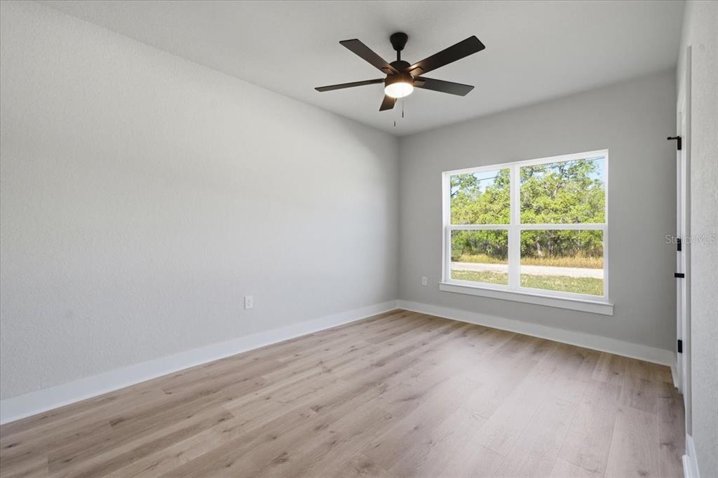 15212 Hawley Road Weeki Wachee, FL 34614 - Photo 20 of 25 an empty room with wooden floor and windows