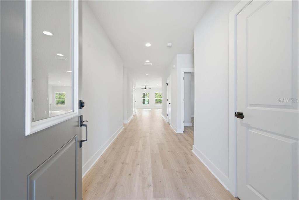 15212 Hawley Road Weeki Wachee, FL 34614 - Photo 3 of 25 a view of a hallway with wooden floor and a bathroom