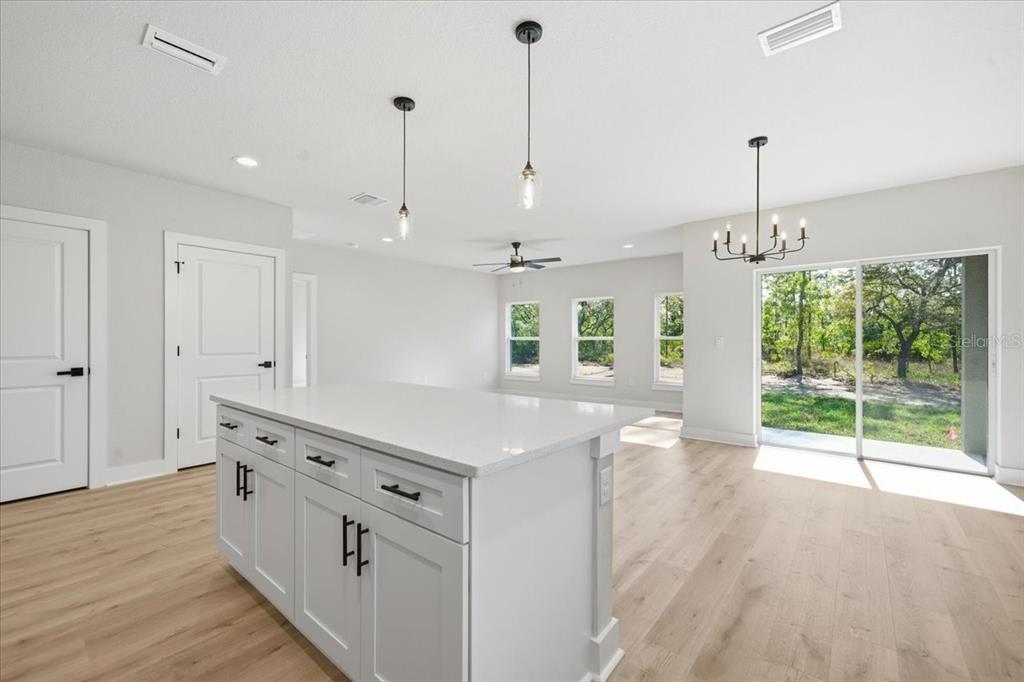 15212 Hawley Road Weeki Wachee, FL 34614 - Photo 7 of 25 a kitchen that has a lot of white cabinets and wooden floor