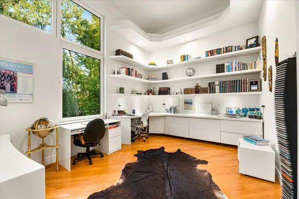 a view of a dining room and livingroom with furniture wooden floor a chandelier
