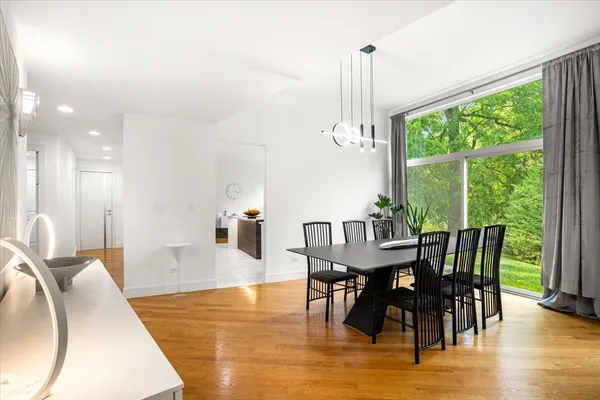 a room with kitchen island a sink wooden floor and a living room view